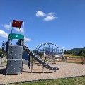 The playground at Creed Fields Park has a slide with a climbing wall and multiple climbing structures..