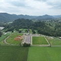 An aerial view of Creed Fields Park shows the layout of the entire facility with a walking track around the perimeter and a view of the surrounding mountains.