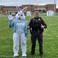 Easter Bunny waves paw while Sheriff's deputy gives two thumbs up.